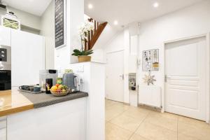 a kitchen with white cabinets and a counter top at Au jardin de la Basilique in Boulogne-sur-Mer +14 photos