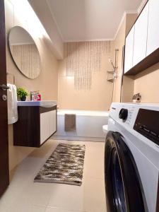 a washing machine in a bathroom with a tub at Sweet Home Apartment in Piteşti