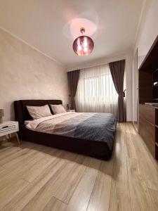 a bedroom with a large bed and a large window at Sweet Home Apartment in Piteşti