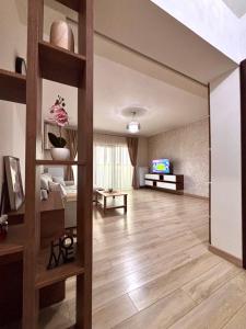 a living room with wooden floors and a large mirror at Sweet Home Apartment in Piteşti