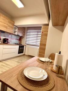 a kitchen with a table with two plates on it at Sweet Home Apartment in Piteşti +6 photos