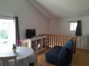 a living room with a table and a blue couch at 35 m2 independent studio in Marillet