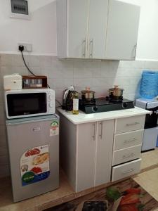 a kitchen with a microwave and a stove at Wema m stays in Munyu