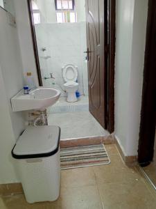 a bathroom with a toilet and a sink and a shower at Wema m stays in Munyu +5 photos