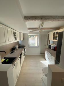 a kitchen with white cabinets and a large window at Casa Eden in Baia Mare