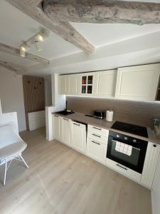 a kitchen with white cabinets and a stove top oven at Casa Eden in Baia Mare +11 photos