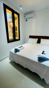 a bedroom with a large white bed with a window at B's House in Pointe-à-Pitre