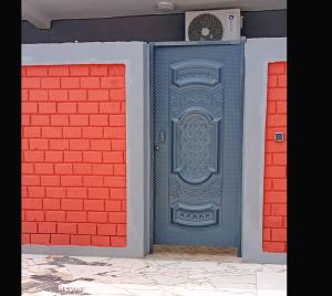 a blue door on the side of a brick wall at Les studios américains d'Angré - 2 in Mandanou