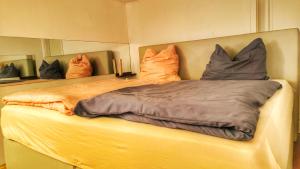 a bed with pillows on it in a room at AMORE 66 bei Greta in Marl