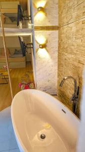 a bathroom with a bath tub and a sink at AMORE 66 bei Greta in Marl