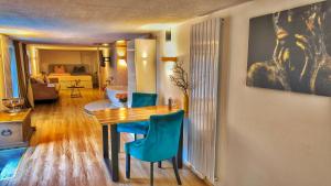 a living room with a dining room table and blue chairs at AMORE 66 bei Greta in Marl