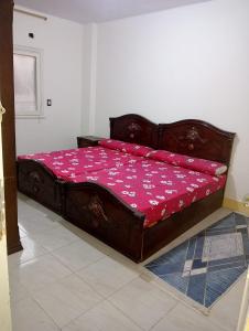 a bedroom with a wooden bed with pink sheets at Nour Tours in Cairo
