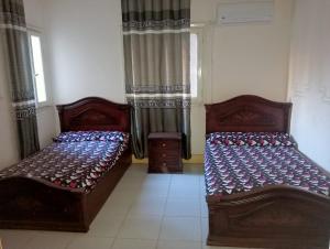 two beds sitting in a room with windows at Nour Tours in Cairo +8 photos