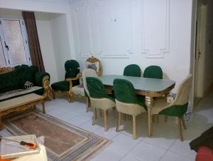 a dining room with a table and green chairs at Nour Tours in Cairo