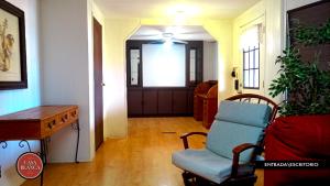 a hallway with a chair and a table and a door at Casa Blanca Hotel Campestre in Francisco Zarco