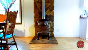 a stone fireplace in a living room with a chair at Casa Blanca Hotel Campestre in Francisco Zarco