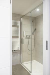 a shower with a glass door in a bathroom at Hôtel au Heimbach in Lembach +92 photos