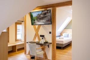 a room with a bed and a table and a tv at Hôtel au Heimbach in Lembach