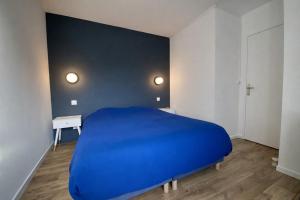 a bedroom with a blue bed and a blue wall at Le #7 - Centre ville - Parking privé - Balcon in Saint-Omer
