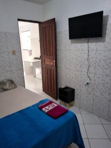 a bedroom with a bed and a flat screen tv at Apto 04 em São Bras in Belém