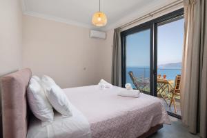 a bedroom with a bed and a view of the ocean at Irida sunset in Pentátion