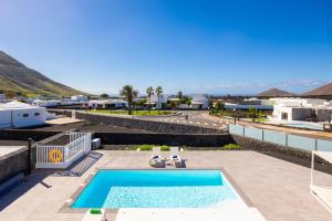 a villa with a swimming pool and a view of the ocean at Villa Yaiza Secret 1 in Yaiza