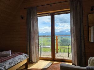 a bedroom with a large window with a view at Alpine Chalet with Jacuzzi and Sauna in Czerwienne