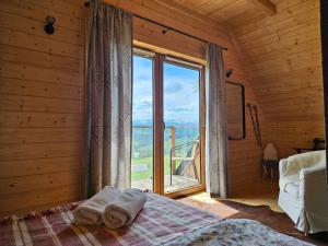 a bedroom with a bed and a large window at Alpine Chalet with Jacuzzi and Sauna in Czerwienne