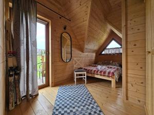 a bedroom with a bed in a wooden cabin at Alpine Chalet with Jacuzzi and Sauna in Czerwienne +20 photos