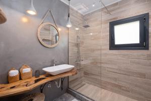 a bathroom with a sink and a glass shower at Irida sunset in Pentátion +41 photos