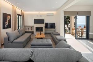 a living room with a couch and a tv at Irida sunset in Pentátion