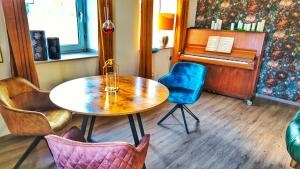 a table and chairs in a room with a piano at AMORE 69 bei Greta in Marl +18 photos