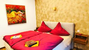 a bedroom with two beds with red pillows and a painting at AMORE 69 bei Greta in Marl