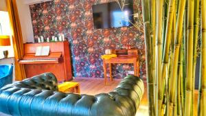a living room with a leather couch and a tv at AMORE 69 bei Greta in Marl