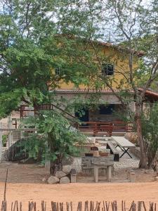 a bench and a picnic table in front of a building at Chalé Encontro das Pedras na Serra in Serra de São Bento