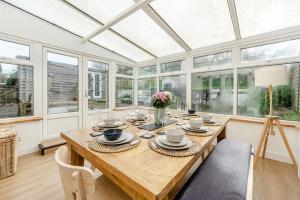 a dining room with a wooden table and windows at 3 Bed in Croyde oc-s34664 in Croyde