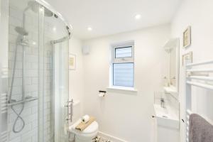a white bathroom with a shower and a toilet at 3 Bed in Croyde oc-s34664 in Croyde +14 photos