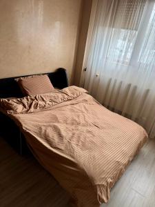 an unmade bed in a bedroom with a window at Sunset Home Apartment in Galaţi