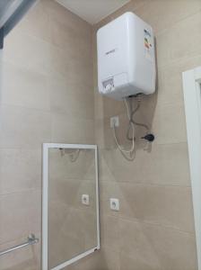 a shower in a bathroom with a mirror at LBranco in Porto Novo