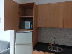 a kitchen with a white refrigerator and a microwave at LBranco in Porto Novo