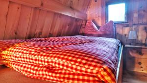 a bedroom with a red and white checkered bed at Finnhütte bei GRETA in Marl