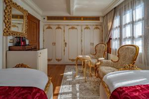 a bedroom with two beds and a table and chairs at Princess Farida Luxury Dahabiya Nile Cruise, Every Monday from Luxor to Aswan 4 nights and Every Friday from Aswan to Luxor 3 nights in Luxor