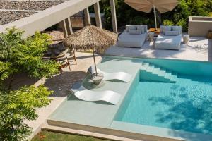 a swimming pool with chairs and an umbrella and a table at Luxury 5BR Villa with Pool Jacuzzi 2 Golf Carts in Punta Mita +41 photos