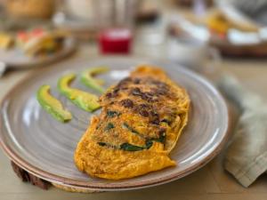 a omelet on a plate with vegetables on a table at Pietra Hotel in Sáchica