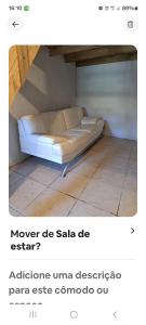 a white couch sitting in a room with a floor at Loft centro do universo in Arroio do Sal