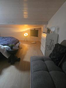 a bedroom with a bed and a couch and a lamp at B&B MaMi in Agno