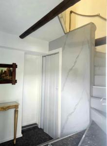 a room with a white marble wall and stairs at B&B MaMi in Agno +11 photos