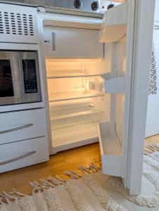 a refrigerator with its door open with a microwave at Private Studio with Bathroom and Kitchen, Central Location in Tromsø