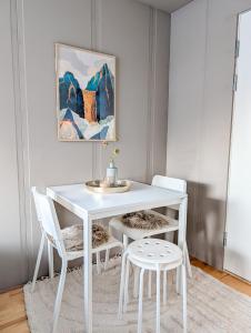 a white table and chairs in a room with a painting at Private Studio with Bathroom and Kitchen, Central Location in Tromsø