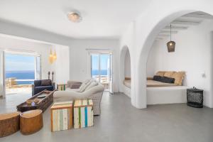 a white living room with a couch and a table at Boutique Villa Aquata Private pool in Mikonos